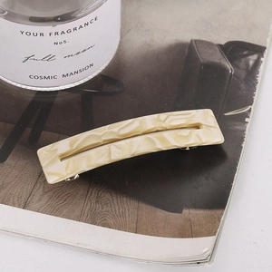 Close-up of elegant cream marble acetate hair clip with hollow rectangular design