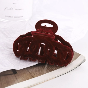 Dark red velvet hair claw clip with cutout chain design on elegant white background