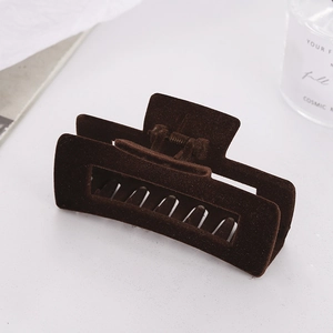 Macro shot of large coffee brown flocked hair claw clip with geometric cutout and metal spring