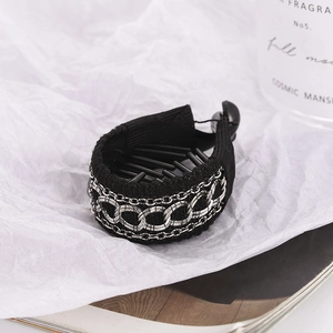 Barrette banane noire élégante avec triple chaîne argentée sur fond blanc structuré