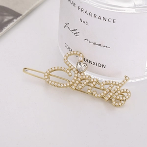Elegant gold metal hair clip with pearls and heart crystal forming a smile shape