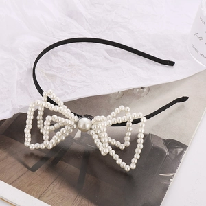 Elegante cerchietto per capelli con fiocco di perle bianche su una base nera sottile