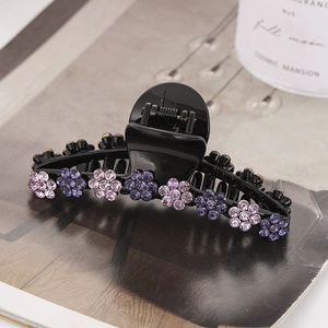 Pince à cheveux fleur noire avec strass violets sur un fond de magazine de mode élégant