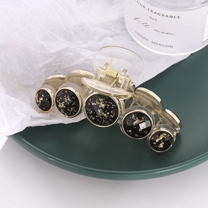 French style gold foil hair claw clip with black circular buttons and metal spring