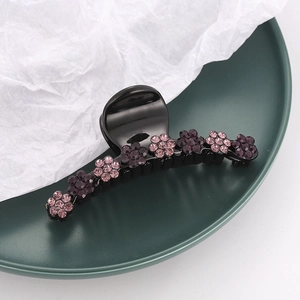 Gros plan d'une pince à cheveux élégante avec fleurs et strass roses et violets