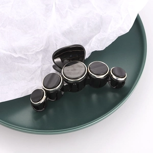 Retro circular hair claw clip in black resin with silver-edged shell patterns