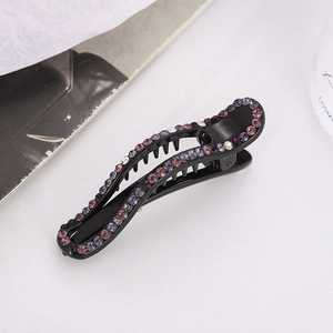 Detail of a black hair clip with purple rhinestones and non-slip grip teeth
