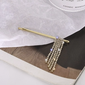 Eleganter goldener Haarclip mit glitzernden Strass-Quasten im koreanischen Minimalismus