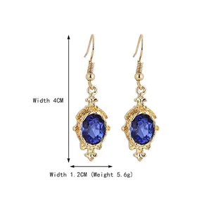 Elegant gold drop earrings with oval blue faceted gemstones and vintage textures