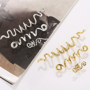 Dettaglio di fermagli per capelli a spirale celtica in oro e argento per trecce