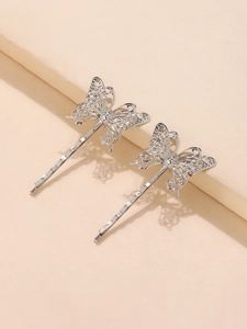 Close-up van twee zilveren holle vlinder haarspeldjes met metalen textuur