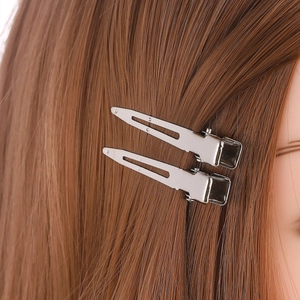 Pair of minimalist silver metal duckbill hair clips shown on brown hair for styling