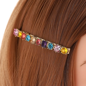 Fermaglio per capelli dorato con cristalli colorati su modella con capelli castani