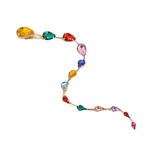 Peigne à cheveux avec cristaux colorés en forme de goutte et base dorée sur fond blanc