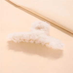 Close-up of fluffy cream plush hair claw clip showing soft faux fur texture for winter