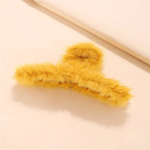 Detailed close-up showing soft yellow plush texture on an elegant winter hair claw clip