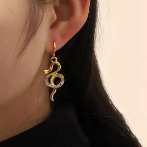 Elegant gold snake drop earrings with sparkling crystal pavé stones on a model