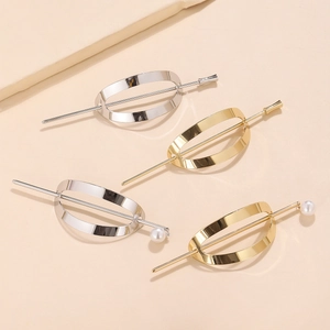 Nahaufnahme von vier minimalistischen Metallhaarnadeln in Gold und Silber mit Perlenanhänger