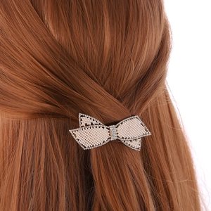 Elegante fermaglio per capelli a fiocco con perle bianche e strass su capelli castani