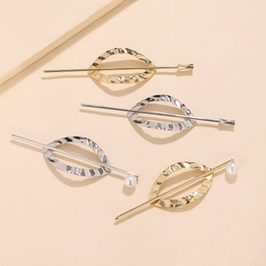 Detail of four gold and silver geometric hair pins with hollow leaves and white pearls