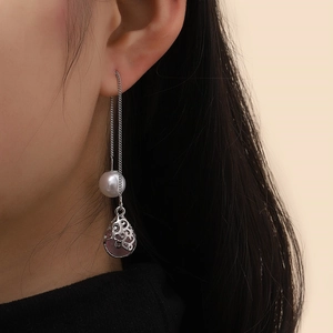 Detail showing the elegant silver chain with white pearl and purple teardrop pendant