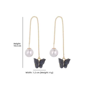 Detailed view of long gold tassel earrings with pearls and butterfly pendants, 10.6cm long