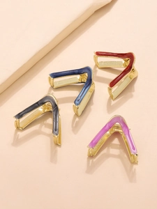 Flat lay macro view of four colorful V-shaped metal hair claws in polished gold finish