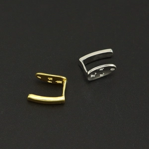 Détail de boucles d'oreilles en U dorées et argentées avec motifs d'étoiles et fini métal