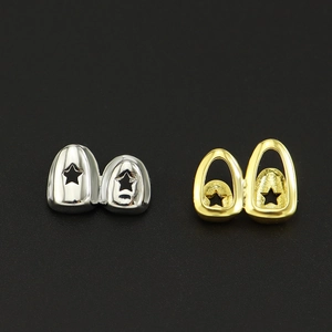 Gros plan de grillz hip hop dorés et argentés avec un design d'étoile creuse et fini miroir