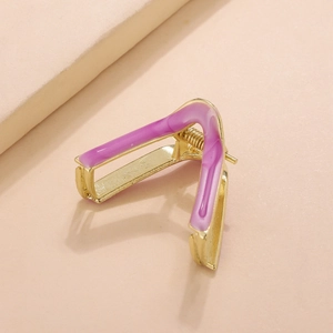Detail of a minimalist gold V-shaped hair claw with smooth purple enamel finish