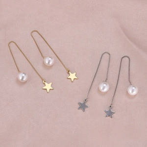 Detail of star and pearl drop earrings featuring delicate metal chain tassel design