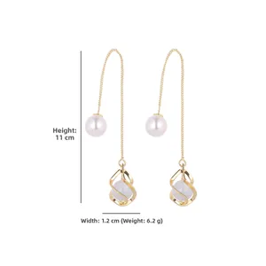 Detailed view of long gold tassel earrings with pearls measuring 11cm in length