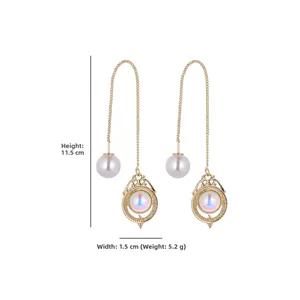 Detail view of long gold tassel earrings with pearl and opal stone with dimension measurements