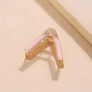 Detail view of the V-shaped golden alloy hair claw clip with pink enamel coating