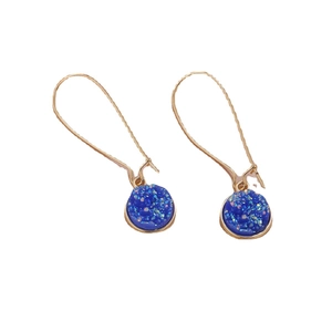 Eleganti orecchini a gancio dorati con cristalli rotondi in resina druzy blu su sfondo bianco