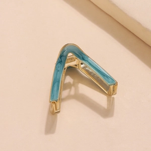 Detail of blue marble finish on golden V-shaped metal hair clip with a sturdy spring