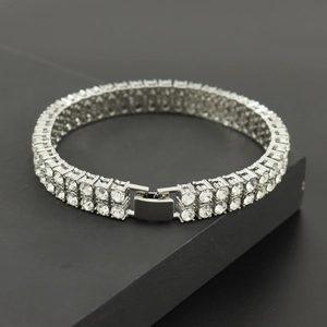 Macro detail of silver double-row tennis bracelet with sparkling zircon stones and fold-over clasp