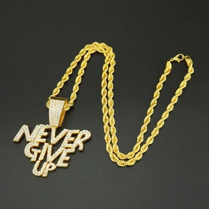 Detalle del colgante hip hop dorado con letras Never Give Up y cristales brillantes