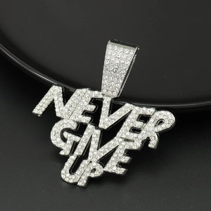 Primer plano de colgante hip hop plateado con lema NEVER GIVE UP y cristales claros