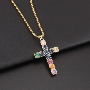 Colorful zircon cross pendant necklace with golden box chain on black leather background