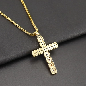 Close-up of golden cross pendant with colorful cubic zirconia and sturdy box chain