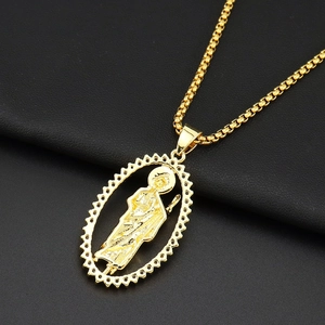 Gros plan détaillé du pendentif ovale doré de saint sur cuir noir texturé