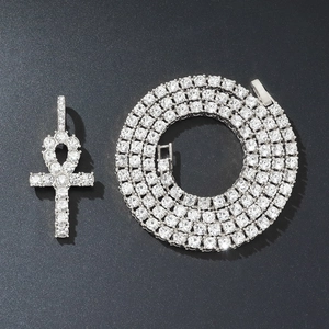 Detailed view of silver Ankh cross pendant and iced-out tennis chain with shiny crystals