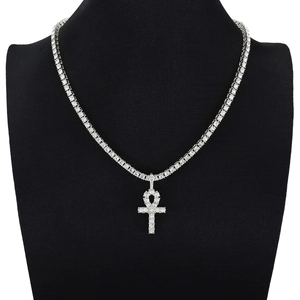 Close-up of hip-hop tennis chain and full diamond Ankh cross pendant on black display