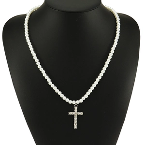 Collier élégant en perles avec pendentif croix en strass argenté sur mannequin de cou