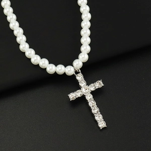 Gros plan du collier avec pendentif croix en perles, strass brillants et finition argent