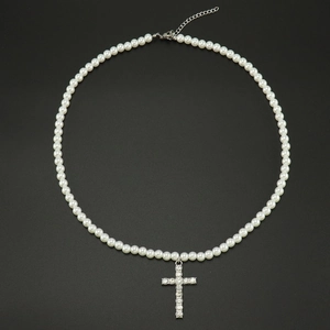 Détail du collier de perles avec pendentif croix en strass et fermoir réglable pratique