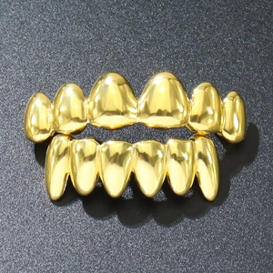 Macro shot of 18k gold-plated hip hop vampire teeth grillz set with mirror finish
