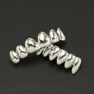 Macro view of silver hip-hop teeth grillz set with mirror-polished surface on black background