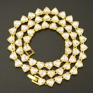Close-up of golden heart-shaped tennis necklace with sparkling cubic zirconia gems